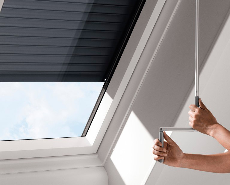 Hände, die Rolläden mit einer Kurbelstange schließen