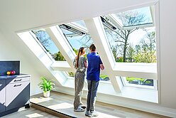 Kinder gucken aus dem Dachfenster