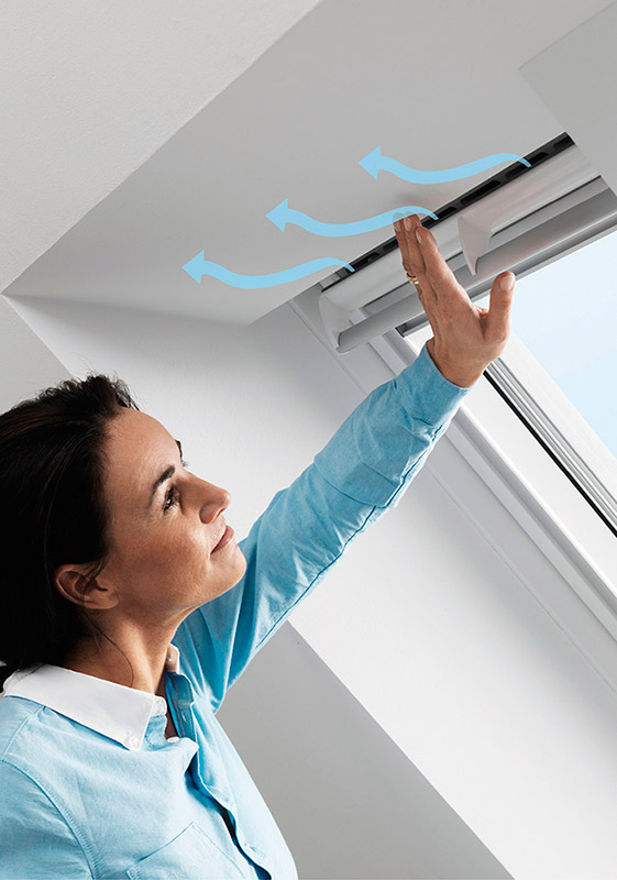 Frau spürt den Luftzug an der Lüftungsklappe