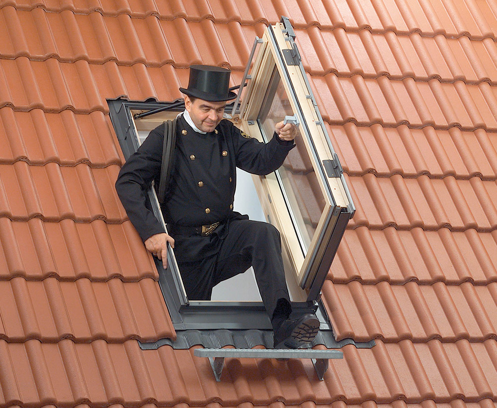 Schornsteinfeger, der aus einem Ausstiegsfenster steigt