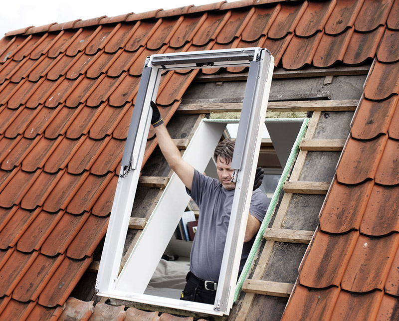 Handwerker beim Einbau eines Dachfensters