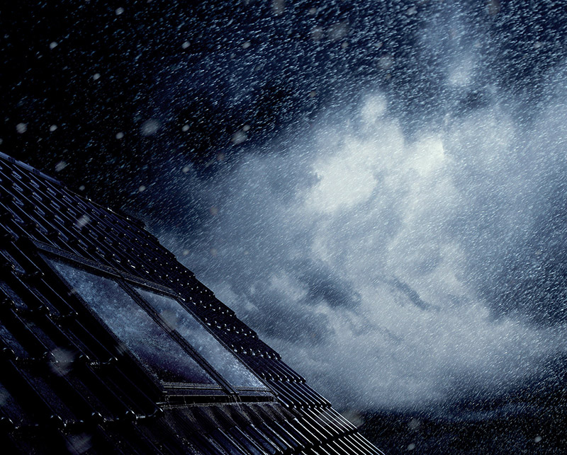 Dach mit Dachfenster im Regen